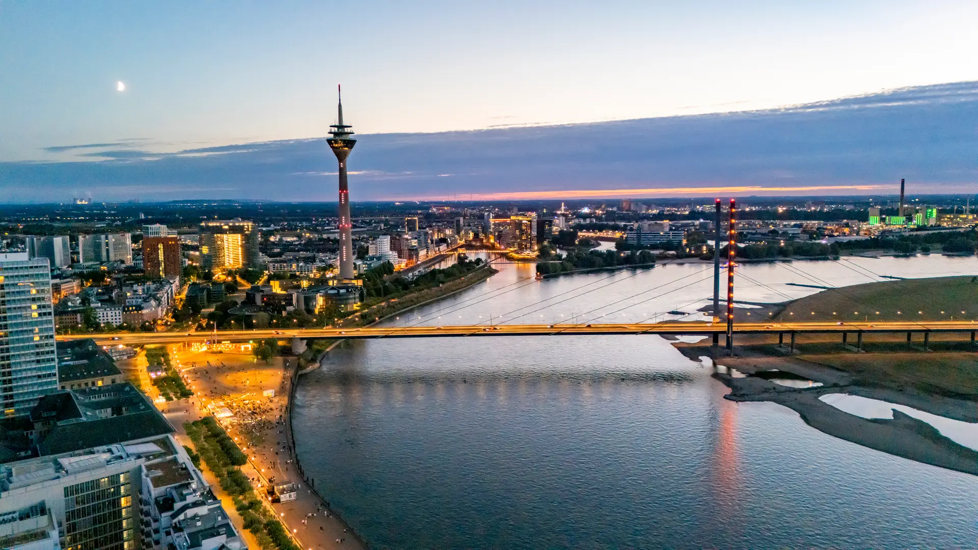 Düsseldorfer Skyline mit Rheinturm und Rheinbrücke in der blauen Stunde über dem Rhein