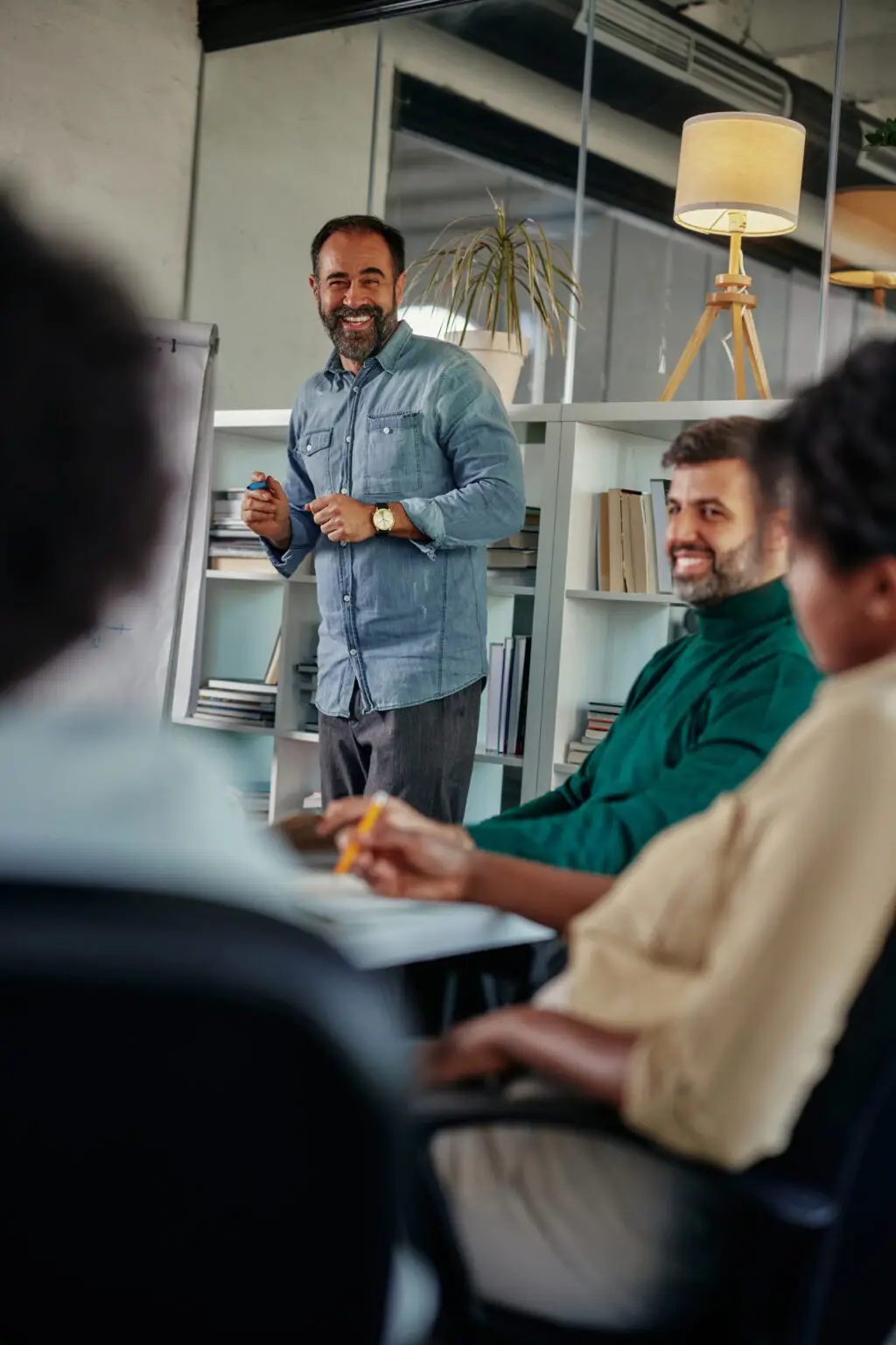 Teammeeting mit Präsentation am Flipchart in modernem Büro mit konzentrierter Arbeitsatmosphäre