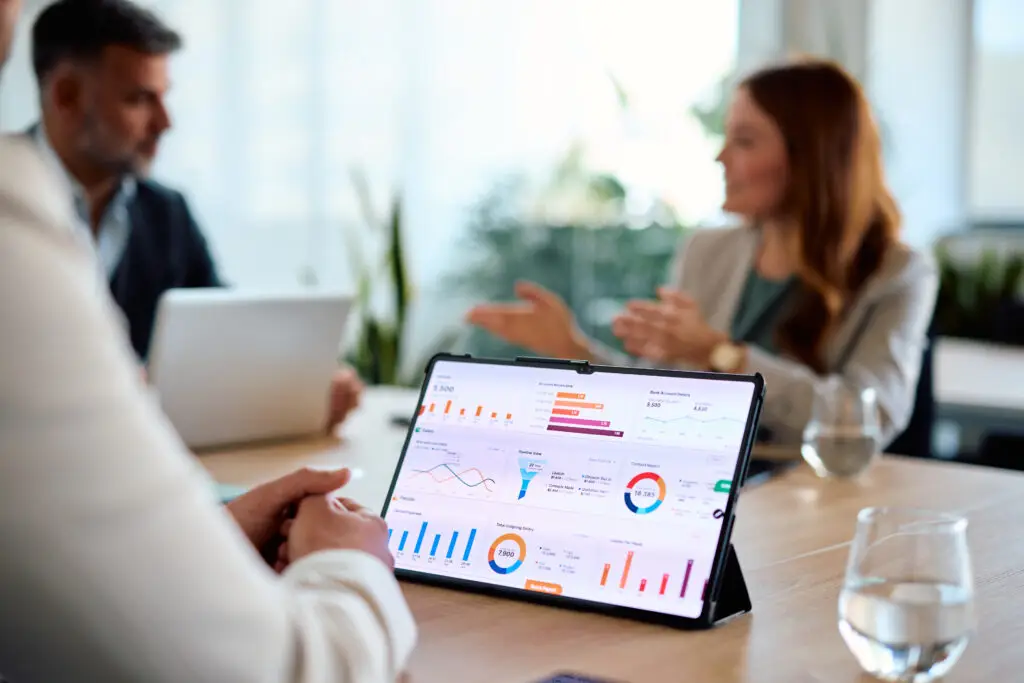 Tablet mit Analytics Dashboard auf Besprechungstisch im Business Meeting