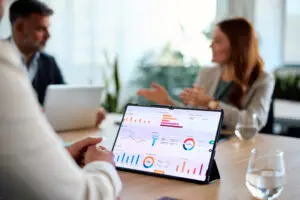 Tablet mit Analytics Dashboard auf Besprechungstisch im Business Meeting